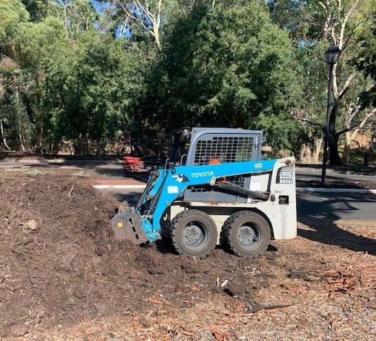 Digger mulching a garden bed